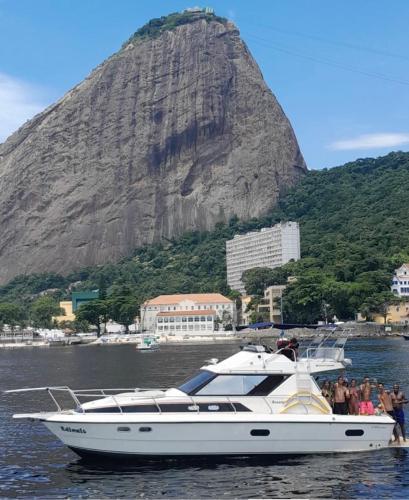 a boat in the water with a mountain in the background at Passeio Privativo de Lancha no RJ in Rio de Janeiro
