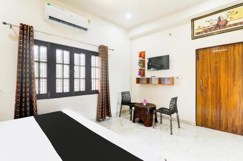 a room with a bed and two chairs and a table at Hotel O Serene Inn Hotel And Restaurant in Lucknow