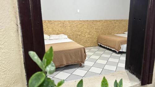 a bedroom with two beds and a mirror at Casa Piauí Hostel in Teresina