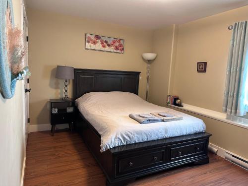 a bedroom with a bed with a black bed frame at Separate entry sweet home in Victoria
