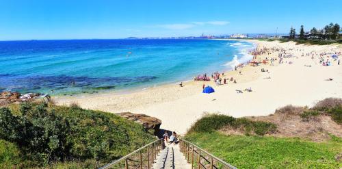 a beach with a bunch of people on the beach at Surfside 22 in Wollongong