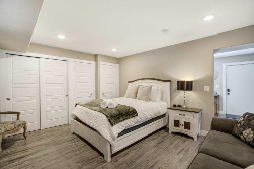a bedroom with a white bed and a couch at Vermijo Nook Walk to OCC Downtown w Fire Pit in Colorado Springs