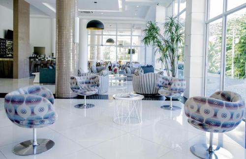 a lobby with chairs and tables in a building at Flat Porto Marina Mont Blanc in Mangaratiba