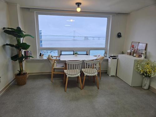 a dining room with a table and chairs and a large window at 에벤에셀 in Busan