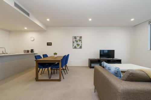 a living room with a table and blue chairs at Convenient City Apartment in the Heart of Braddon - Hosted by Canstay in Braddon