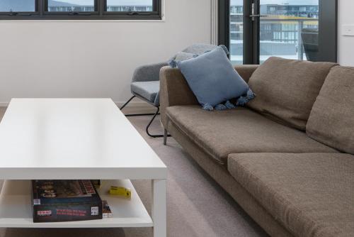 a living room with a couch and a table at Convenient City Apartment in the Heart of Braddon - Hosted by Canstay in Braddon