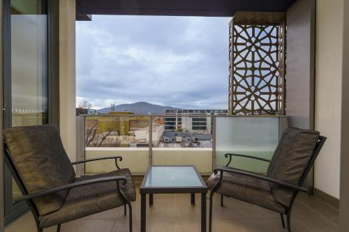a balcony with two chairs and a table and a window at Convenient City Apartment in the Heart of Braddon - Hosted by Canstay in Braddon