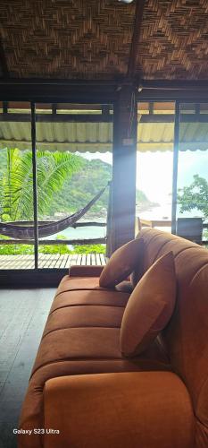 a couch in a living room with a view of a mountain at Chabalay Resort in Koh Tao