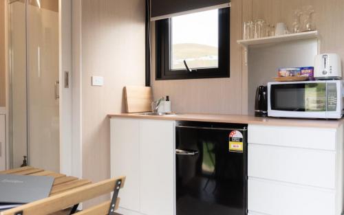 a small kitchen with a microwave and a counter top at Weka Pass Cottages 2 by Tiny Away in Waikari
