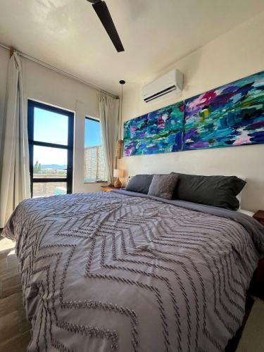 a bedroom with a large bed with a painting on the wall at Casa Mantra Ocean View & Private Terrace in La Ventana