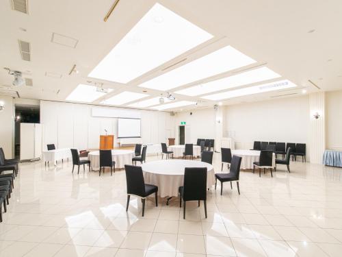 a large room with tables and chairs in it at Hotel Verfort Hyuga in Hyuga