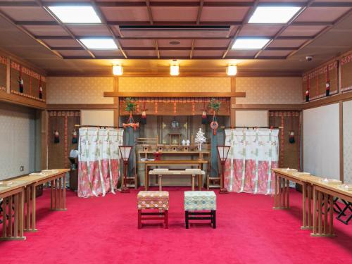a room with a ping pong table and chairs at Hotel Verfort Hyuga in Hyuga