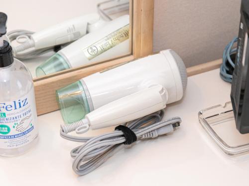 a hair dryer sitting on a desk next to a mirror at Hotel Verfort Hyuga in Hyuga