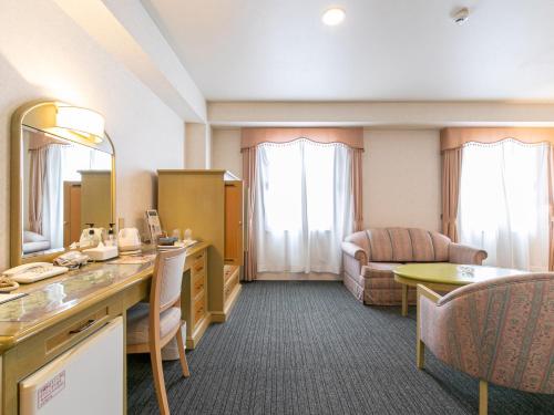 a hotel room with a vanity and a living room at Hotel Verfort Hyuga in Hyuga