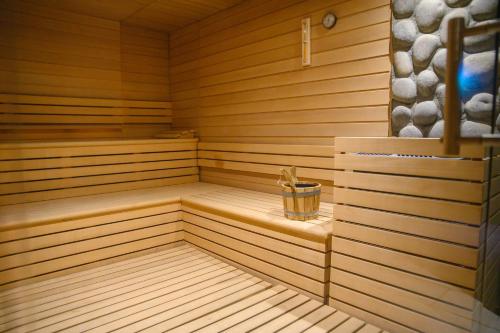 a wooden sauna with a bucket in the middle at voco - Podgorica by IHG in Podgorica