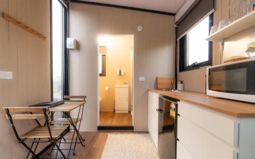 a small kitchen with a table and a microwave at Weka Pass Cottages 3 by Tiny Away in Waikari