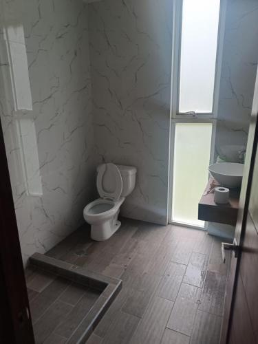 a bathroom with a toilet and a sink at Casa blanca in Santa María Atlihuetzián