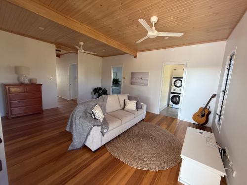 a living room with a couch and a ceiling fan at Beach house at Bangalee in Farnborough