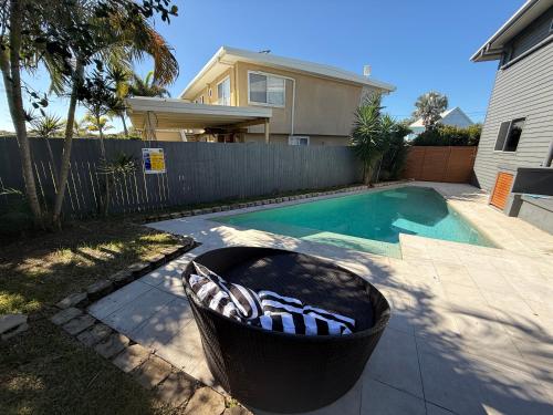 a swimming pool with a trash can next to a house at Beach house at Bangalee in Farnborough