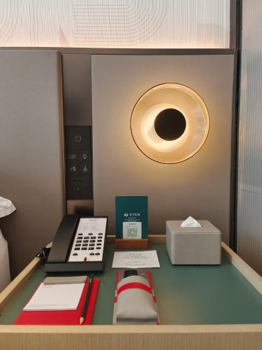 a room with a desk with books and a light at EVEN Hotel Zhongshan City Center by IHG in Zhongshan