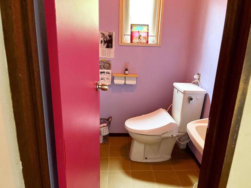 a pink bathroom with a toilet and a sink at Guesthouse HOALOHA 4 SEASONS in Chino