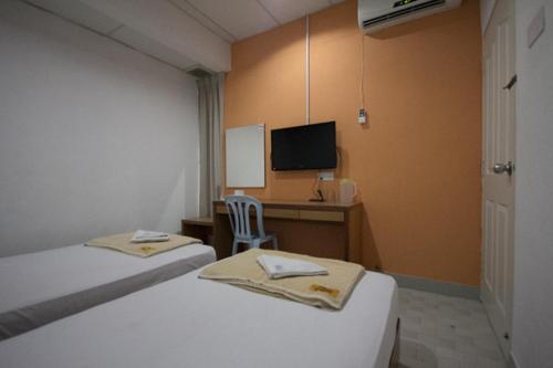 a room with two beds and a desk with a computer at Bahagia Stay Georgetown in George Town