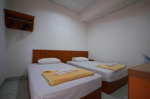two beds in a small room with white walls at Bahagia Stay Georgetown in George Town