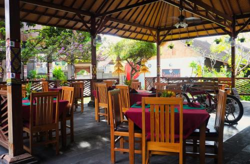 a group of tables and chairs in a restaurant at Rumah Gajah by Kubukubali in Pemuteran