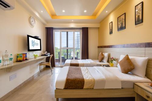 a hotel room with two beds and a television at Windchime 331 in Gurgaon