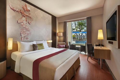 a hotel room with a large bed and a desk at Mercure Bali Nusa Dua in Nusa Dua