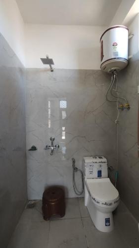 a small bathroom with a toilet and a sink at Hatu View Homestay in Nārkanda