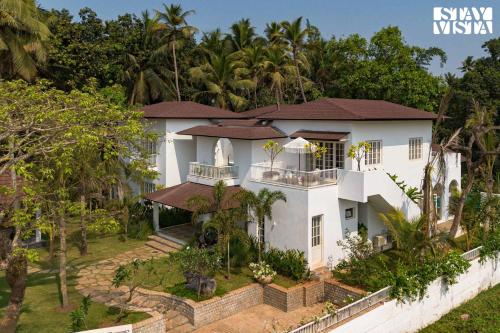 an aerial view of a white house with trees at StayVista at Villa Selene - Dolly J Homes with Pool in Sangolda