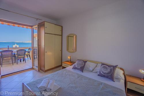 a bedroom with a bed with a view of the ocean at Zutenica Seaside Residence in Metajna