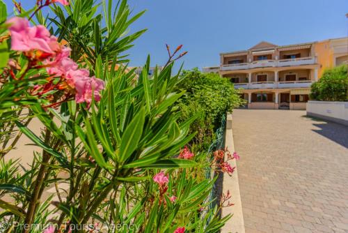 a row of plants and flowers in front of a building at Zutenica Seaside Residence in Metajna