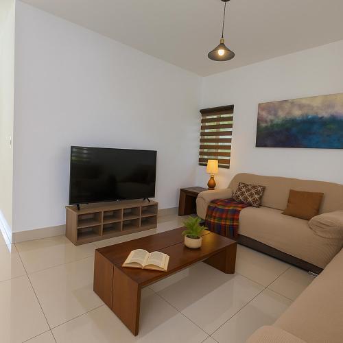 a living room with a couch and a flat screen tv at Mansion Cumbres Vista Panoramica Monterrey in Monterrey