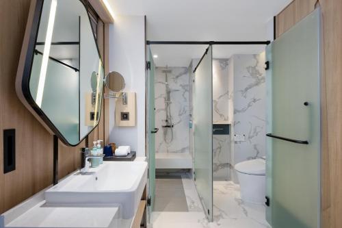 a bathroom with a sink and a mirror at Novotel Rayong Star Convention Centre in Rayong