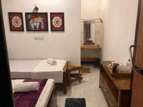 a room with two beds and a table in it at Ceylon Beach haven Uppuveli in Trincomalee
