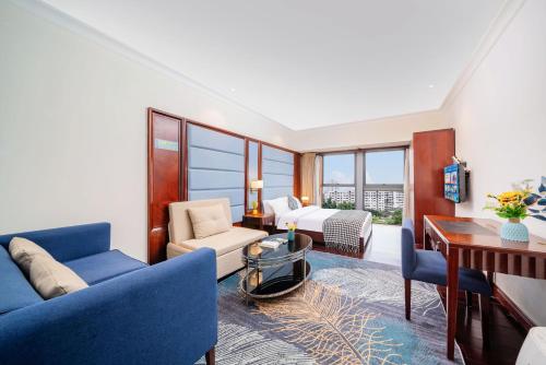 a living room with blue chairs and a table and windows at Fa万濠国际服务公寓 广州琶洲会展中心店 in Guangzhou