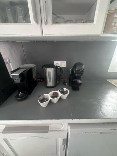 un comptoir de cuisine avec trois tasses à mesurer et une cafetière dans l'établissement Maison 3chambres avec piscine, à Istres