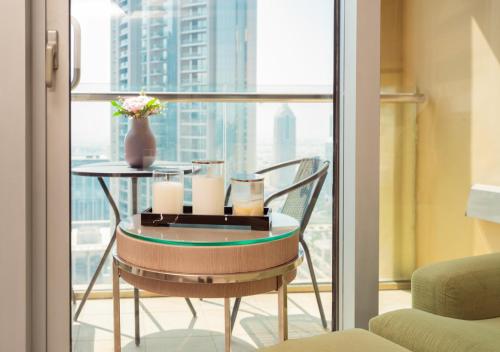 a table with candles and a vase on a balcony at Fashion Avenue Dubai Mall in Dubai