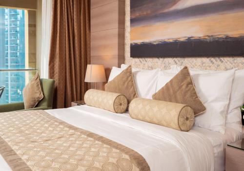 a hotel room with a white bed with pillows at Fashion Avenue Dubai Mall in Dubai