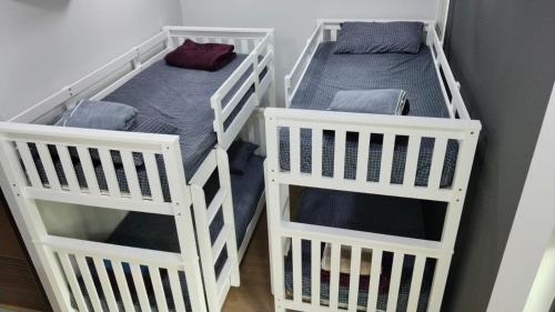 three white bunk beds in a room at The Family Suites Serviced Apartments in Singapore