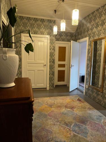 a room with a vase on a table and a door at Kulla Skola in Veddige
