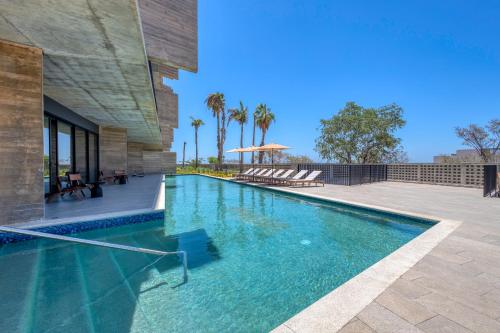 a swimming pool in front of a building at OR Cabo Boutique Residences by Lumina in Cabo San Lucas