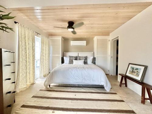 una camera da letto con un letto bianco e un soffitto in legno di Waterfall Pool Villa with Private Mini Golf Course a Coral Bay