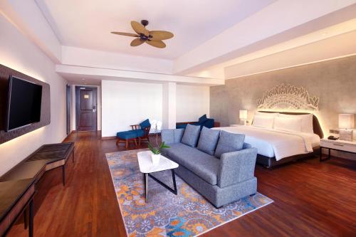 a hotel room with a bed and a couch at Grand Mercure Bali Seminyak in Seminyak