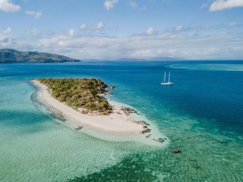 an island with a sail boat in the ocean at Sailing Vessel Summer Jo 2 Night Voyage, Pricing is for 2 Nights All Inclusive Food in Airlie Beach