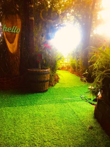 a garden with green grass next to a building at Serendipity Lake Artistic Bungalow by Heidis Home in Nuwara Eliya