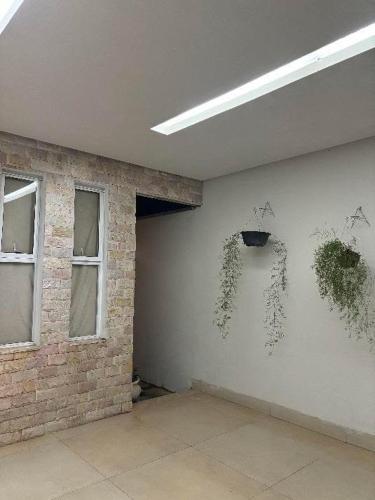 an empty room with plants on the wall at Casa linda em Goianésia! in Goianésia