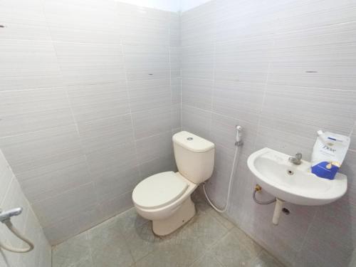 a bathroom with a toilet and a sink at RedDoorz at Griya Jeniee Near Stadion Wilis Madiun in Madiun